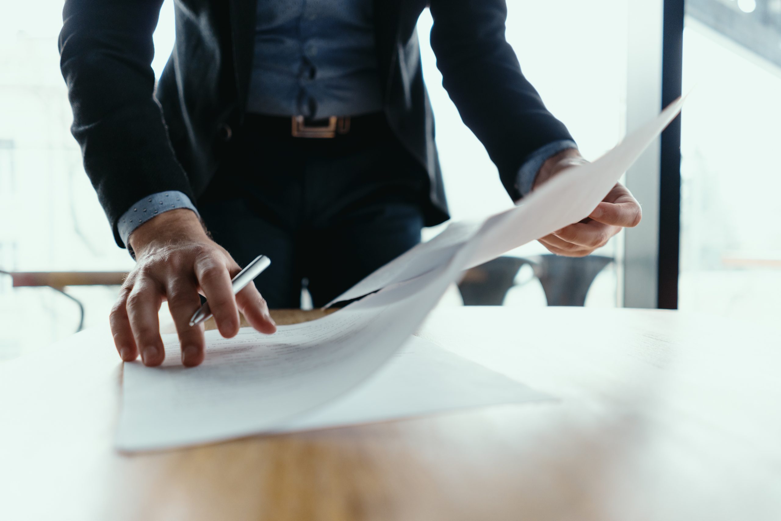 Successful business man signing documents in a modern office